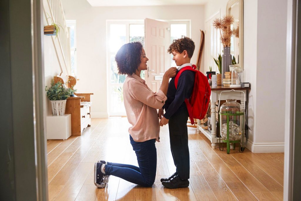 Photo of mother and son, as she fixes his tie before he goes off to school.