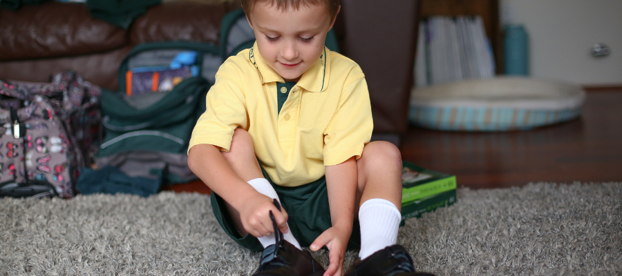 Little boy getting dressed for school